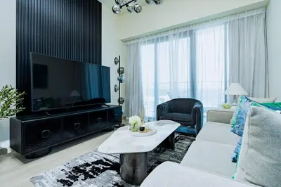 a living room with a large flat screen tv at Nasma - Modern 3BR Oasis with Balcony in Azizi Riviera in Dubai
