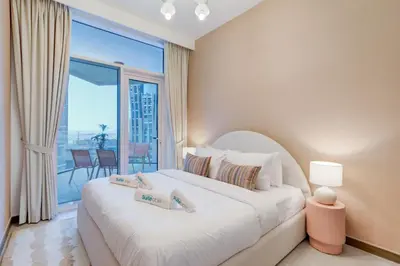 a bedroom with a large bed and a large window at Luxury 1 bedroom Apartment in Urban Oasis by Missoni in Dubai