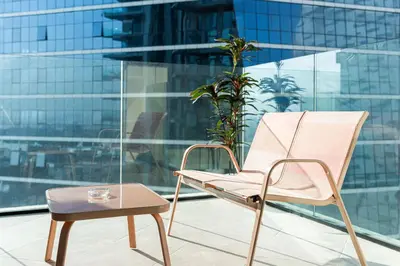 a chair and a table in front of a building at Luxury 1 bedroom Apartment in Urban Oasis by Missoni in Dubai