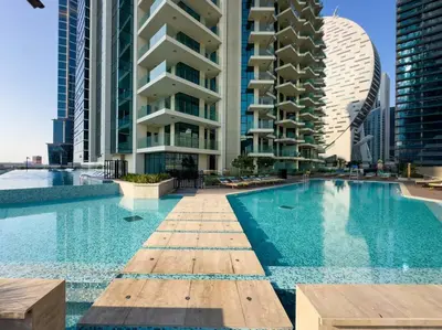a swimming pool in a city with tall buildings at Luxury 1 bedroom Apartment in Urban Oasis by Missoni in Dubai