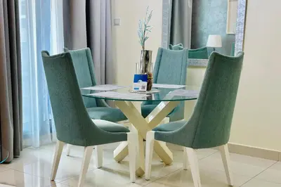 a dining room table with four chairs and a table at Vserve - 1 BR Iconic Burj Khalifa full view in Dubai