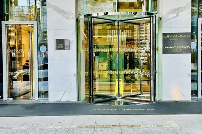 a store front with gold revolving doors on a building at Vserve - 1 BR Iconic Burj Khalifa full view in Dubai