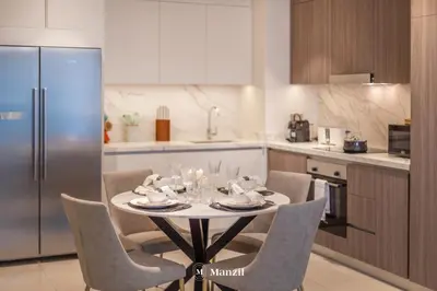 a kitchen with a table and chairs in a kitchen at Manzil - 2BR Apartment in Palm Jumeirah with Marina View in Dubai
