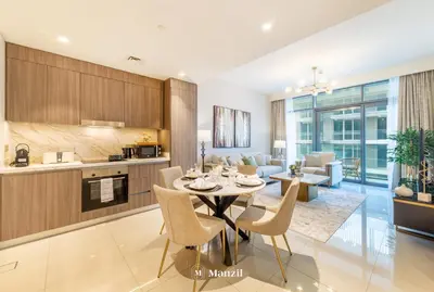 a kitchen and living room with a table and chairs at Manzil - 2BR Apartment in Palm Jumeirah with Marina View in Dubai