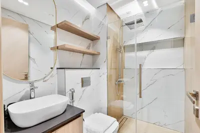 a bathroom with a sink and a shower at Modern Studio with Pool, Gym and BBQ area in Dubai