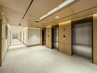 an empty hallway of an office building with elevators at Modern Studio with Pool, Gym and BBQ area in Dubai