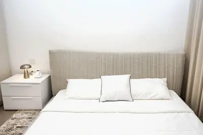 a bed with white sheets and pillows in a bedroom at First class 1BR Hall in Park Heights in Dubai