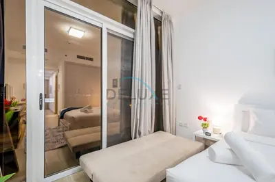 a room with a glass door leading to a living room at Elegant Studio in Bloom Towers B, JVC by Deluxe Holiday Homes in Dubai