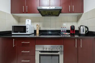 a kitchen with a stove and a microwave at Perfect Stay - 1Bedroom with full Marina View in Dubai