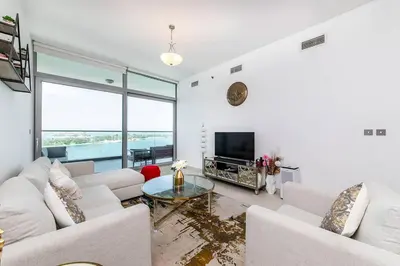 a living room with white furniture and a fireplace at Free Netflix, Sea View, Private Beach & Pool in Dubai