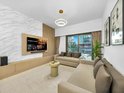 a living room with a couch and a tv at Luxury Downtown Dubai Apartment - 5 Mins Walk to Burj, Opera, Dubai Mall, Sleep 1-10 in Dubai