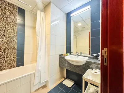 a bathroom with a sink and a bath tub at Vserve - 1 BR Stunning Canal and Burj Khalifa View in Dubai