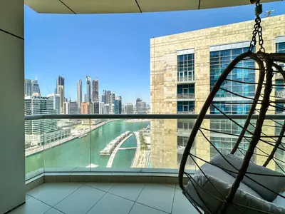 a hammock in a room with a view of a city at Vserve - 1 BR Stunning Canal and Burj Khalifa View in Dubai
