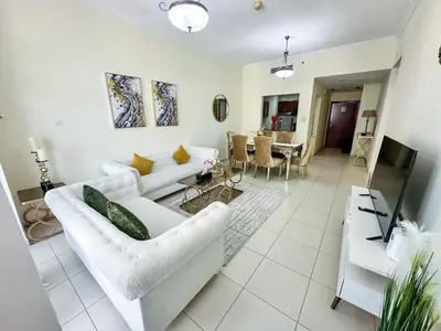 a living room with two white couches and a table at Vserve - 1 BR Stunning Canal and Burj Khalifa View in Dubai
