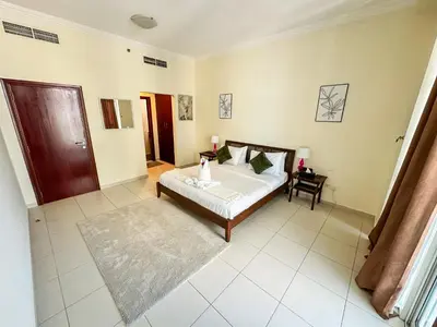 a large bedroom with a bed and a table at Vserve - 1 BR Stunning Canal and Burj Khalifa View in Dubai