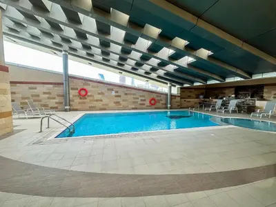 a large swimming pool in a large building at Vserve - 1 BR Stunning Canal and Burj Khalifa View in Dubai