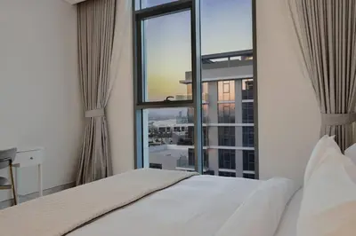 a bedroom with a white bed and a large window at Premium 1BR Haven with Burj Khalifa, City Skyline Views, Pool, Gym & Balcony in Dubai