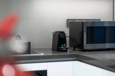 a kitchen with a microwave and a television on a counter at Premium 1BR Haven with Burj Khalifa, City Skyline Views, Pool, Gym & Balcony in Dubai