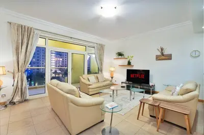 a living room with two couches and a tv at FIRST CLASS 2BR Cozy Beachfront Escape in Dubai