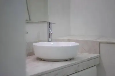 a white sink in a bathroom with a fossett at FIRST CLASS 2BR Cozy Beachfront Escape in Dubai