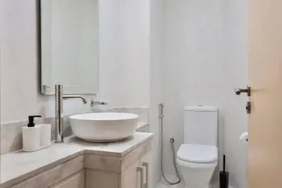 a white bathroom with a sink and a toilet at FIRST CLASS 2BR Cozy Beachfront Escape in Dubai