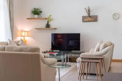 a living room with a couch and a table at FIRST CLASS 2BR Cozy Beachfront Escape in Dubai