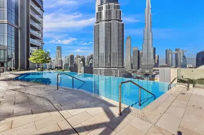 a swimming pool with a city skyline in the background at Skyline Views 2BR Near Burj Khalifa & Dubai Mall with Pool Access in Dubai