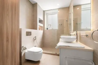 a bathroom with a toilet and a sink and a shower at 2BR Family Apt with Pool, Gym and Jumeirah Lake Views in Dubai