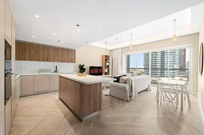 a kitchen and living room with a couch and a table at 2BR Family Apt with Pool, Gym and Jumeirah Lake Views in Dubai