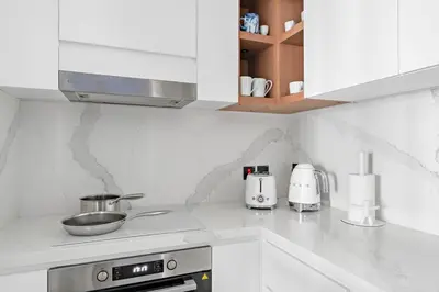 a kitchen with white cabinets and a stove top oven at FIRST CLASS Dubai Marina 2BR with City Views, Balcony, Pool, Gym & Parking in Dubai