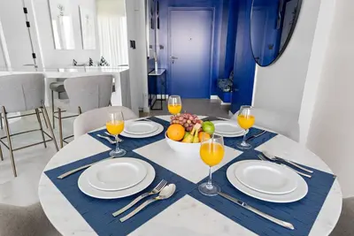 a table with a bowl of fruit and glasses of orange juice at FIRST CLASS Dubai Marina 2BR with City Views, Balcony, Pool, Gym & Parking in Dubai