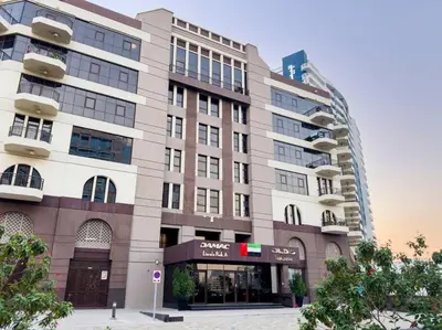 a large building in front of a building at Chic Studio Stay with Gym, Pool, and Kitchenette in Dubai