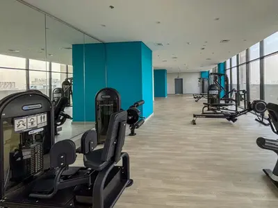 a gym with treadmills and machines in a building at Frank Porter - Azizi Riviera 28 in Dubai