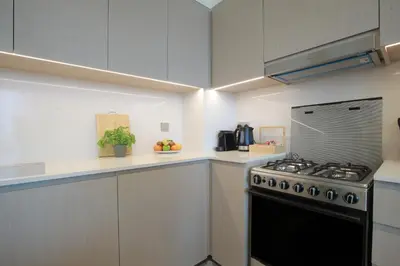 a kitchen with white cabinets and a stove at Burj Khalifa & Fountain Views, Pool, Free Parking in Dubai