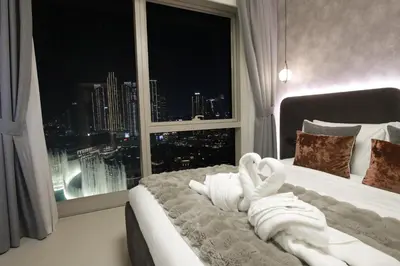 a bedroom with a bed with a window with a view at Burj Khalifa & Fountain Views, Pool, Free Parking in Dubai