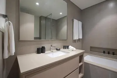 a bathroom with a sink and a mirror and a tub at Burj Khalifa & Fountain Views, Pool, Free Parking in Dubai