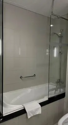 a bathroom with a shower and a bath tub at Downtown Dubai - Damac Maison Mall Street in Dubai