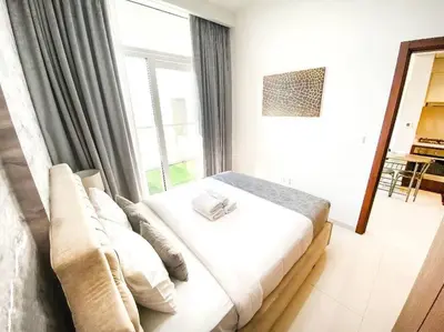 a bed in a room with a large window at Modern Apartment in Downtown Dubai in Dubai