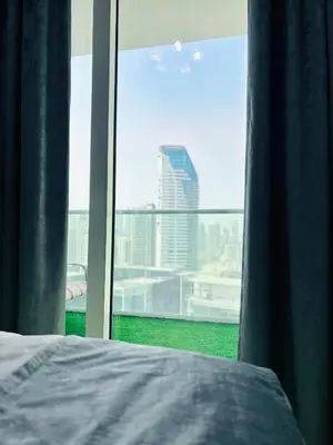 a bedroom with a window with a view of a city at Modern Apartment in Downtown Dubai in Dubai
