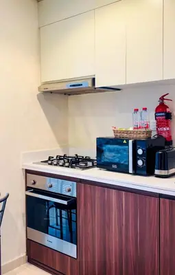 a kitchen with a stove and a microwave at Modern Apartment in Downtown Dubai in Dubai