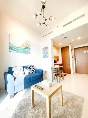 a living room with a blue couch and a table at Modern Apartment in Downtown Dubai in Dubai