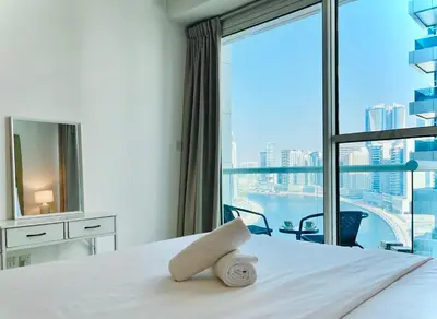 a bedroom with a bed and a large window at Modern 1BR Unit with Canal View Near Burj Khalifa in Dubai