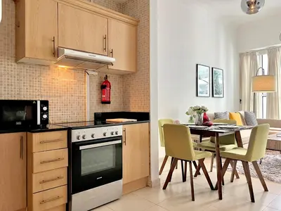 a kitchen with a table and a stove top oven at Modern 1BR Unit with Canal View Near Burj Khalifa in Dubai