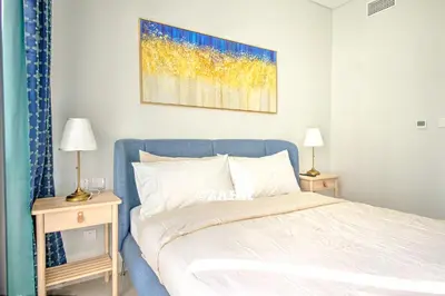 a bedroom with a bed and two tables with lamps at Business bay Chic Apartment in Dubai