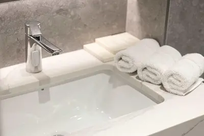 a bathroom sink with towels and a faucet at Legacy by Sunrise - Top Amenities and Paddle Court in Dubai