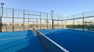 a tennis court with a net on top of it at Legacy by Sunrise - Top Amenities and Paddle Court in Dubai