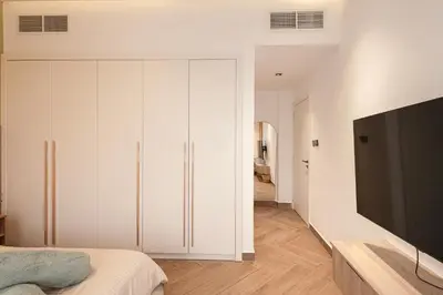 a bedroom with white cabinets and a flat screen tv at Luxurious Villa 5BHK with Pool BBQ and Full Time Housemaid Assistance - live in in Dubai