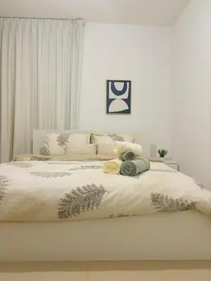 a bedroom with a large white bed with plants on it at Luxury One Bedroom Apartment with Fountain View opposite Dubai Mall in Dubai