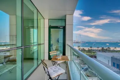 a balcony with a chair and a view of the ocean at Beachy Getaway in JBR with Private Beach Access in Dubai