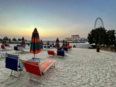a group of chairs and umbrellas on a beach at Beachy Getaway in JBR with Private Beach Access in Dubai
